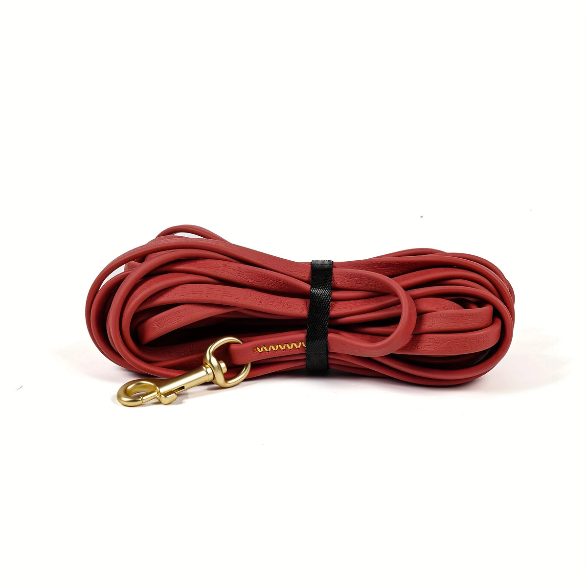 A coiled red heavy-duty waterproof dog leash with a gold-colored clasp and black stitching.
