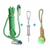 A green cotton rope dog spring pole toy with metal clasps and a tennis ball.