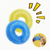 A blue spiky squeaky dog chew toy surrounded by yellow spikes and a dog's paw.