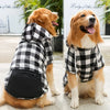 Un golden retriever vistiendo una sudadera con capucha de forro polar a cuadros, sentado en el suelo.