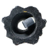A black, porous stone with a central opening and a cylindrical piece inserted into it.