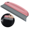 A pink and gray portable lint and pet hair remover brush shown in a diagonal view with a close-up of the bristles.
