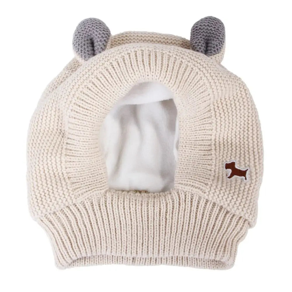 A beige knit ear muff for dogs with soft gray ears and a small brown paw print detail.