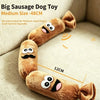 A brown plush sausage dog toy with a squeaker, shown lying on a light-colored fabric.