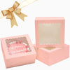 Pink clear window cake boxes with gold ribbon and secure bases