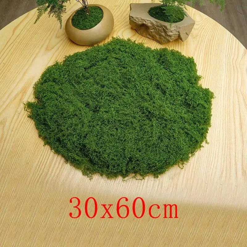 A large, dense patch of green preserved moss displayed on a light wooden surface.