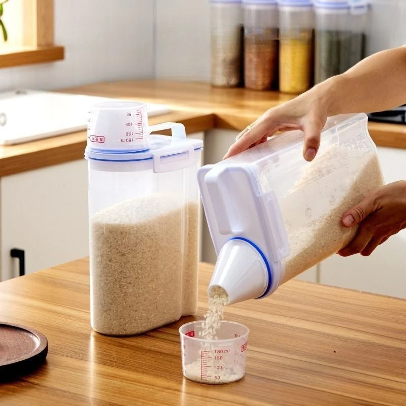 A hand pours pet food from an airtight storage container into a measuring cup on a wooden table.