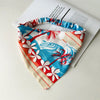 Diadema elástica de estilo boho con estampado floral tropical en blanco, rojo y azul.