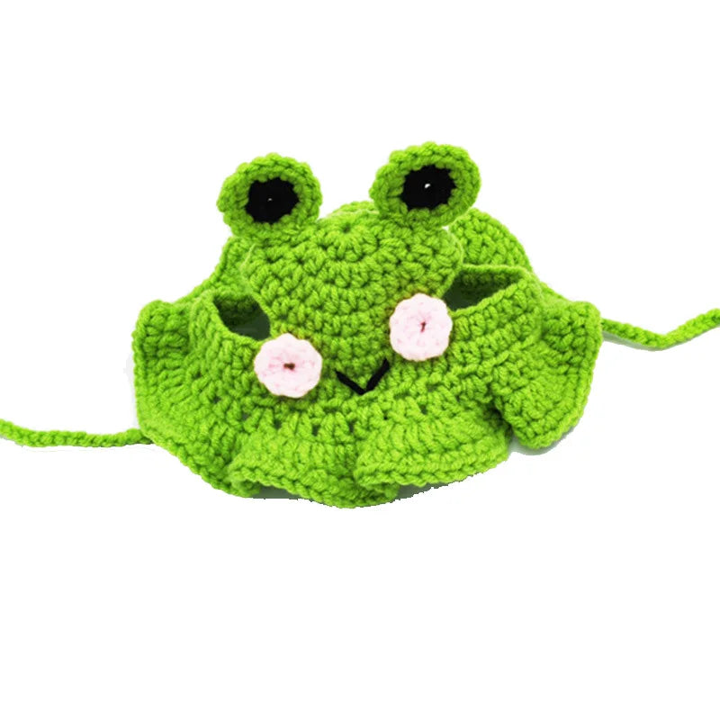 A handmade knitted green frog hat with large eyes and pink accents for pets.