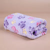 A soft pet fleece blanket featuring a purple background with pink, yellow, and purple paw print designs.