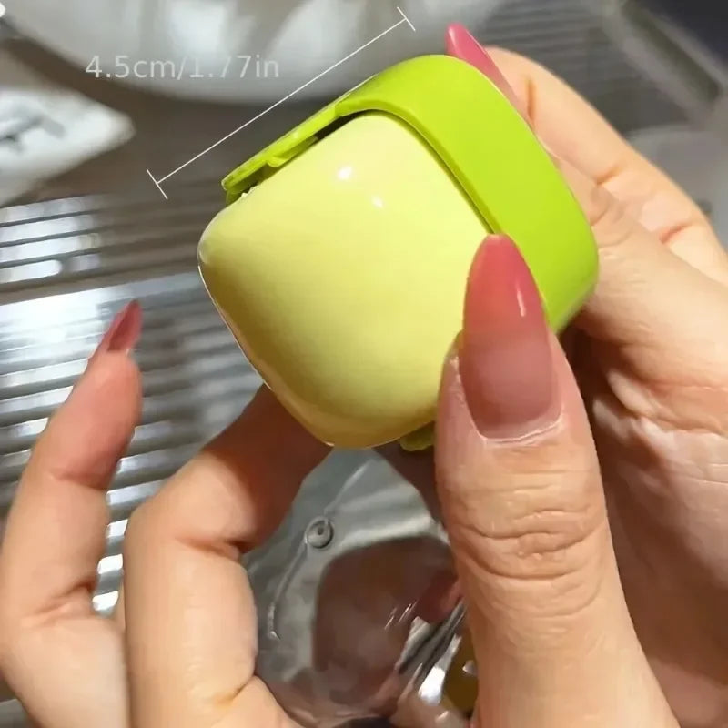 A hand holds a lime green portable lint roller, demonstrating its size with a measurement line.