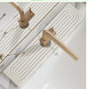 A brass diatomaceous earth absorbent mat is installed on a white countertop, featuring a ribbed design.