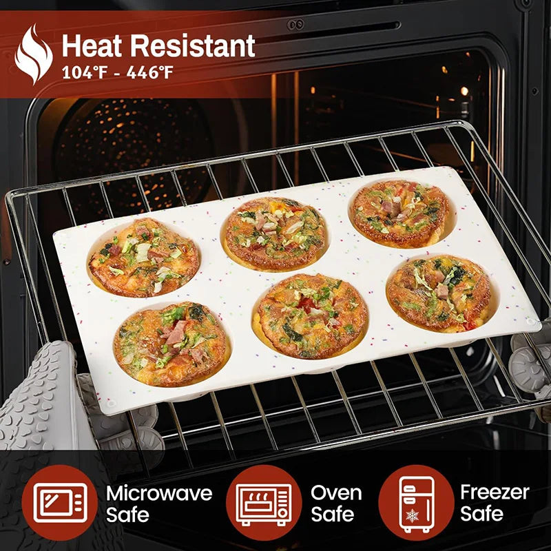 A white silicone baking tray holds several golden egg muffins in a black oven rack.