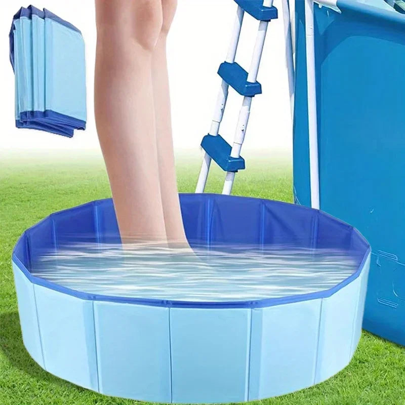 Una piscina plegable azul para mascotas llena de agua, situada sobre césped verde junto a una escalera.