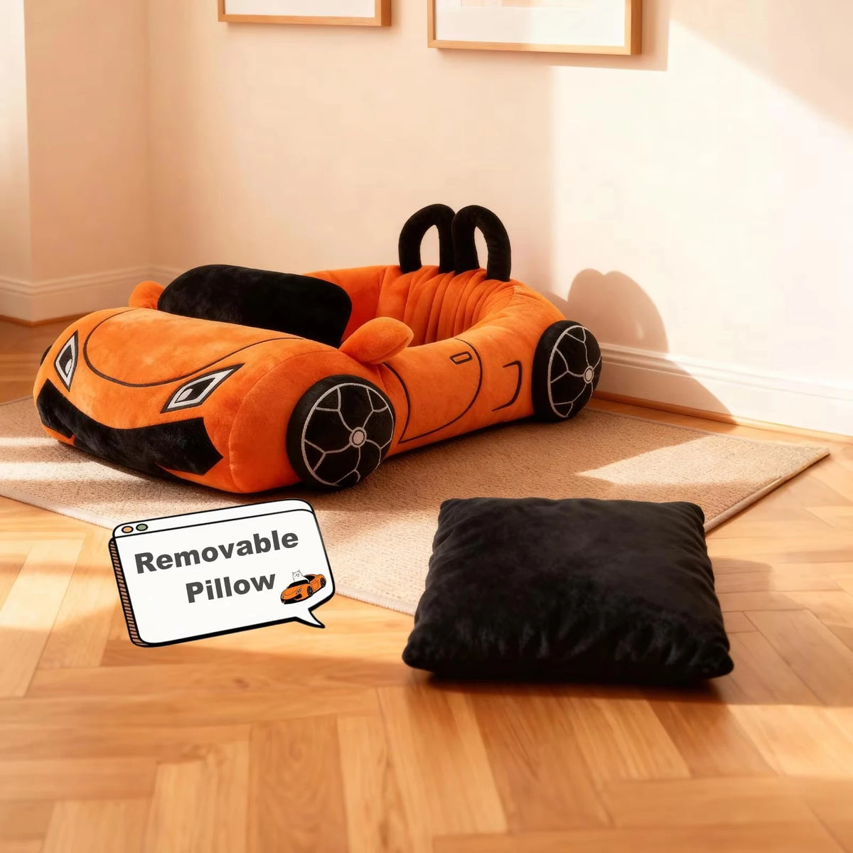 An orange supercar cat bed with black accents and a separate black plush cushion on a wooden floor.