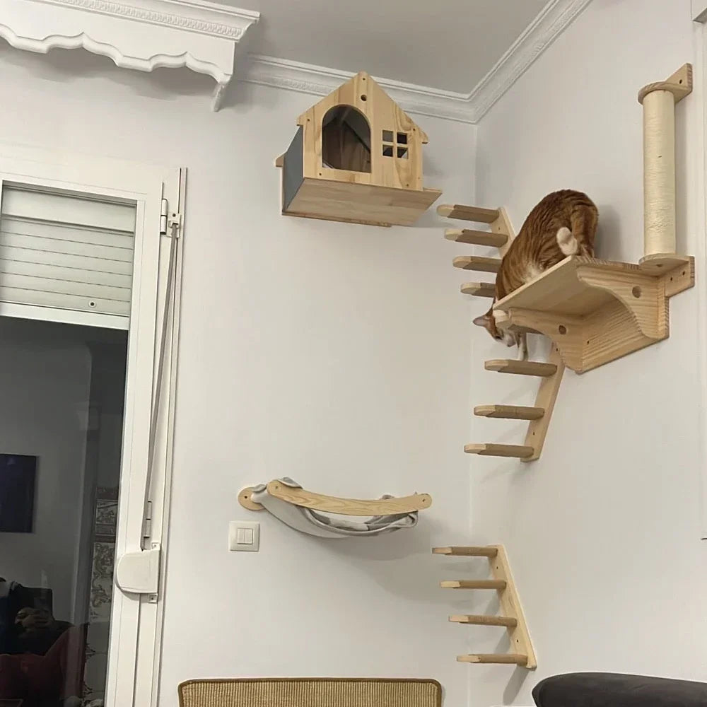Un árbol de gato de madera de varias capas y poste para rascar montado en una pared blanca con un gato descansando en la estr