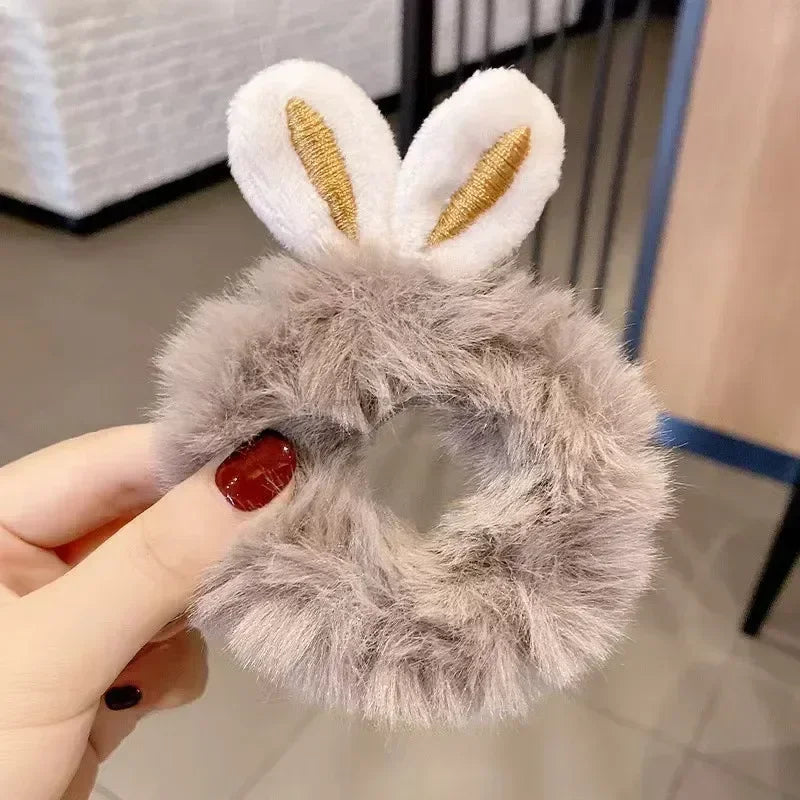 A fluffy gray automatic rolling interactive ball for cats with white ears and a red accent.
