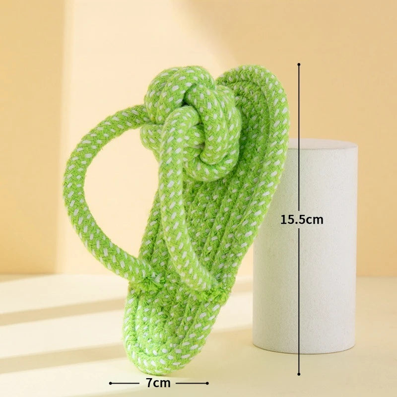 A bright lime green rope ball dog toy made of yarn, shown next to a cylindrical object.