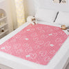 Pink heart pattern reusable absorbent pet pee pads placed on a white surface.