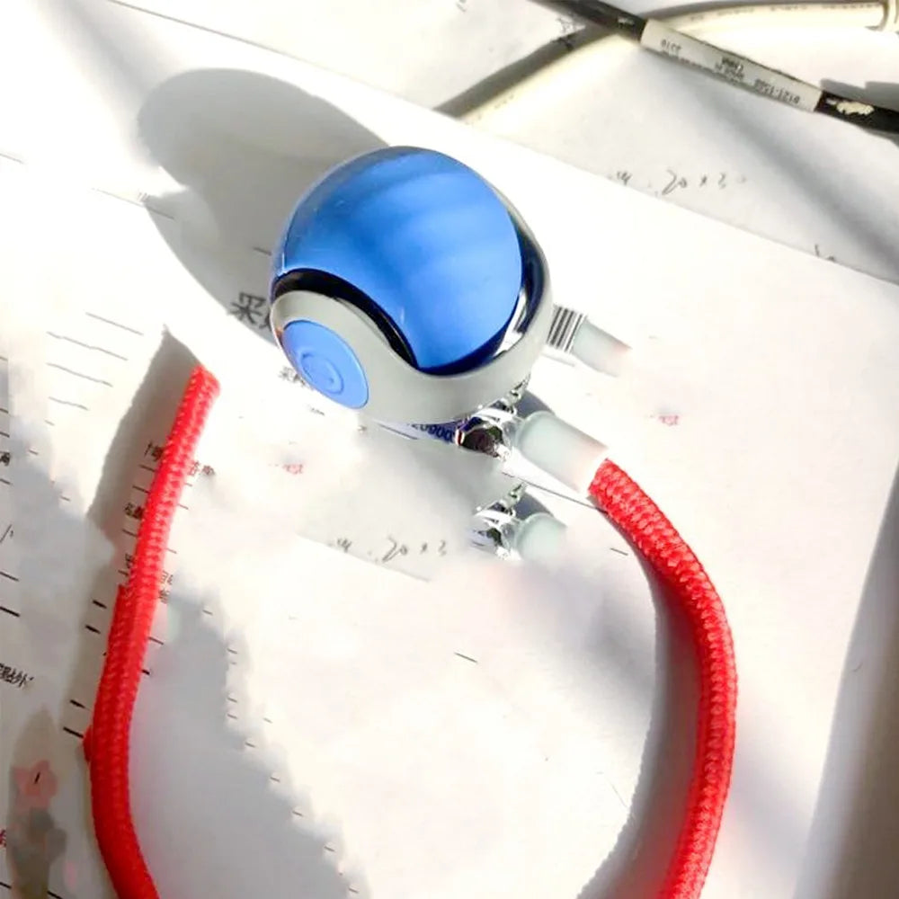 A blue spherical training ball with a white base and red cord is shown on a sheet of paper.