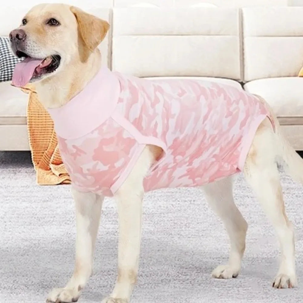 Hellrosa gemustertes Weste für einen Hund, der auf einem grauen Teppich steht.