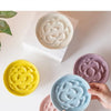 Collection de bols en céramique à nourriture lente pour animaux, dans diverses couleurs pastel, tenus par des mains.
