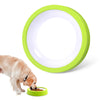 A bright lime green slow feeder bowl is shown with dog food inside, next to a light brown dog.
