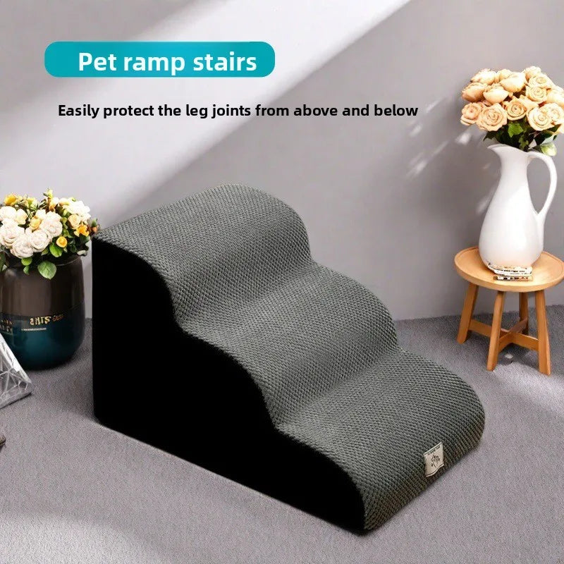 A gray pet ramp stair is shown on a floor, designed to protect leg joints from above and below.