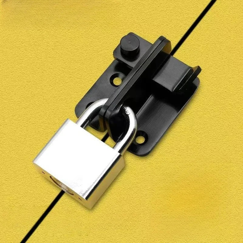 A black sliding bolt lock is mounted on a yellow surface.