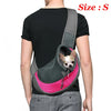 A person is wearing a gray breathable dog sling carrier with a pink lining and a small dog head visible inside.
