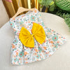Gelbes Kleid für Hund mit Schleife und Blumenmuster auf weißem Grund.