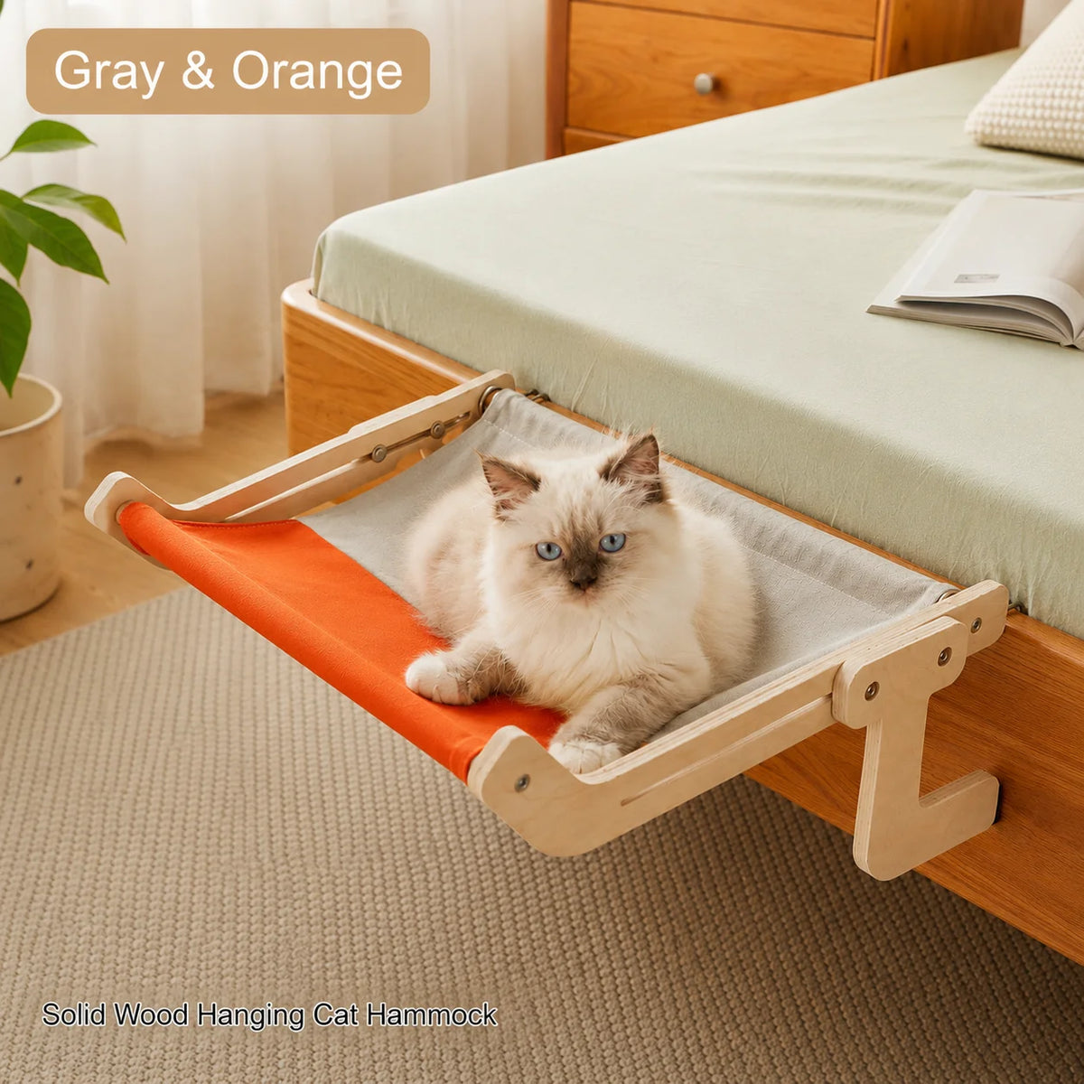 A solid wood hanging cat hammock in orange and gray rests on a wooden bed frame.