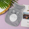 A gray breathable mesh pet vest with a white cartoon cat face print lying on a pink surface.