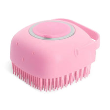 Cepillo y dispensador de champú de silicona rosa para aseo de mascotas con cabeza redondeada y cerdas.