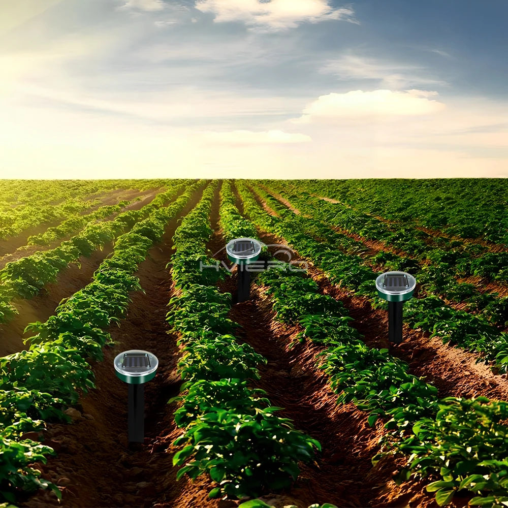 Row of plants with solar powered ultrasonic pest repellers installed in the soil.