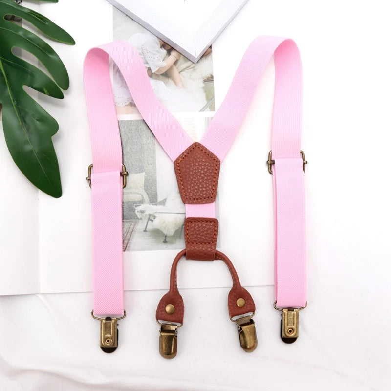 Pink and brown adjustable clip-on suspenders for kids displayed on a white background.
