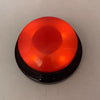 A round, translucent orange button with a black base for dog training.