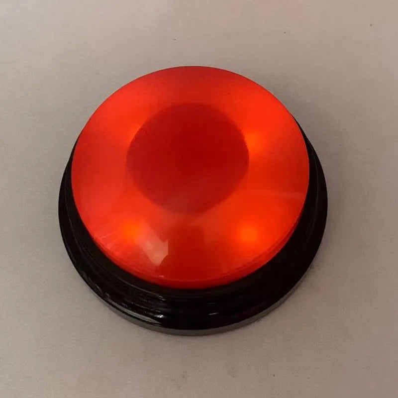 A round, translucent orange button with a black base for dog training.