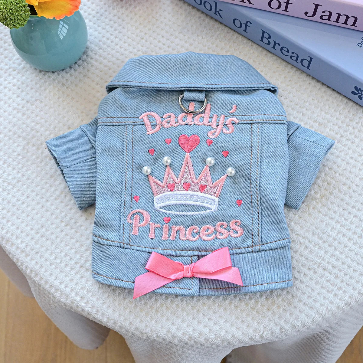 A light blue denim jacket decorated with pink embroidery of a crown and the word Princess for dogs