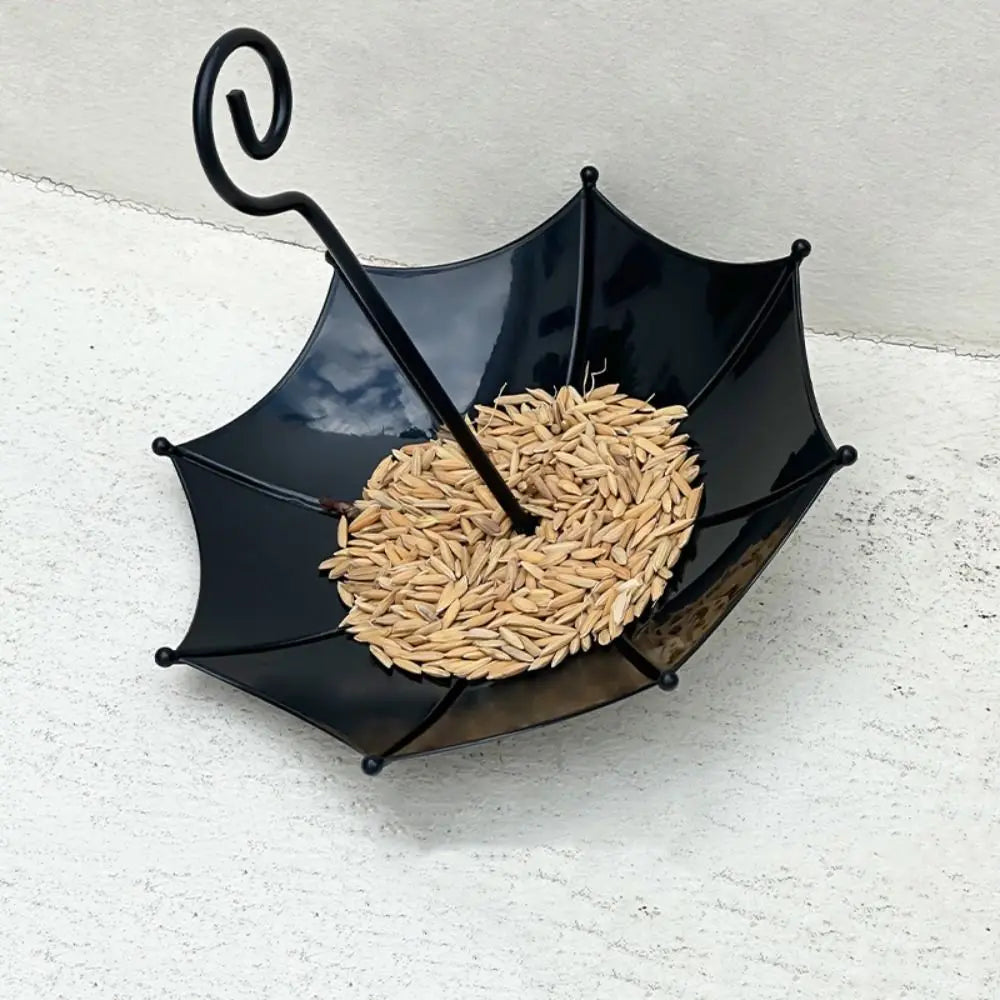 Black umbrella-shaped hanging bird feeder filled with dried seeds