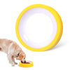 A yellow slow feeder bowl is shown with a dog eating dry food from it.