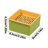 A rectangular, light green planter box with an orange drainage tray and vertical slats for cat grass growing.