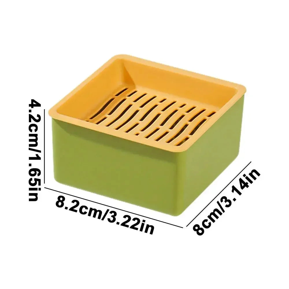 A rectangular, light green planter box with an orange drainage tray and vertical slats for cat grass growing.