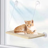A small orange and white cat is resting on a suction cup window hammock bed installed in a window.