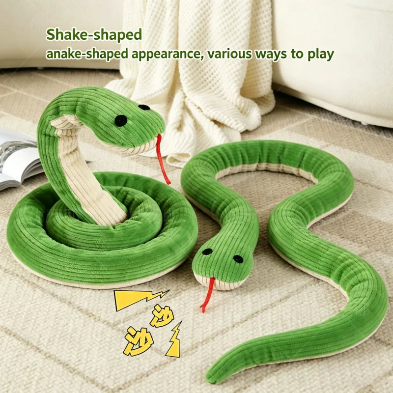 A green snake-shaped toy with an anake-appearance is shown coiled and stretched on a light fabric surface.