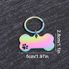 A shiny, iridescent bone-shaped dog ID tag with a metal ring attached, displayed on a dark surface.