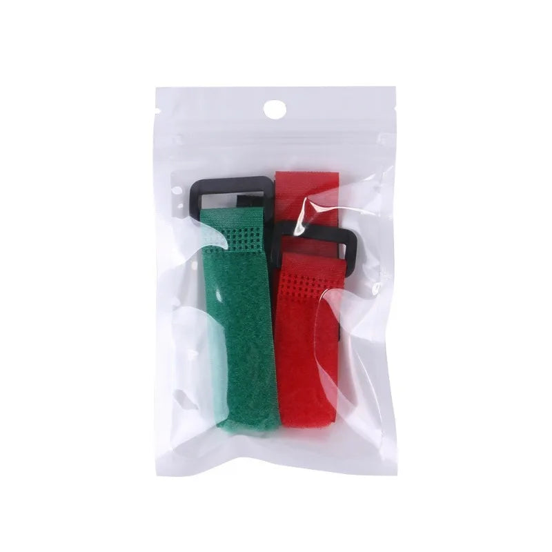 Una bolsa de plástico transparente con dos collares suaves para aves, uno verde y uno rojo.