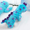 A bright blue and purple fuzzy dinosaur fleece pet hoodie lying on a white surface.
