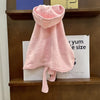 A pink, fluffy multi-purpose pet bath robe for dogs is displayed on a wooden shelf.