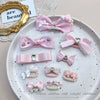 Pink bow hair accessory featuring pearl and rhinestone accents for children's hair.